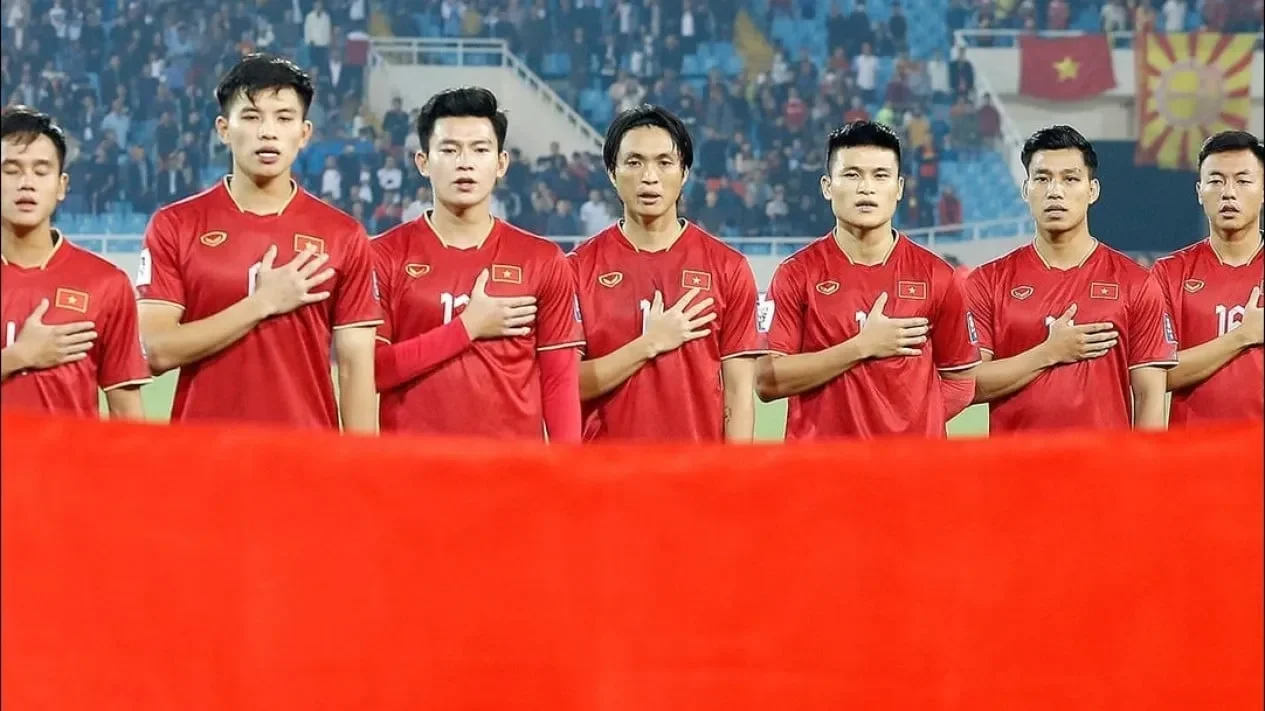 Tim sepak bola Vietnam mengenakan seragam merah dan menghormati lagu kebangsaan mereka.