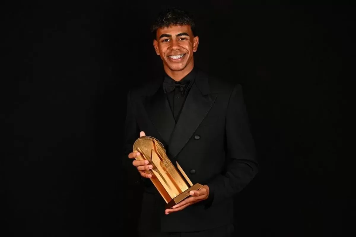 Lamine Yamal memegang trofi pada malam gala Ballon d'Or 2025.