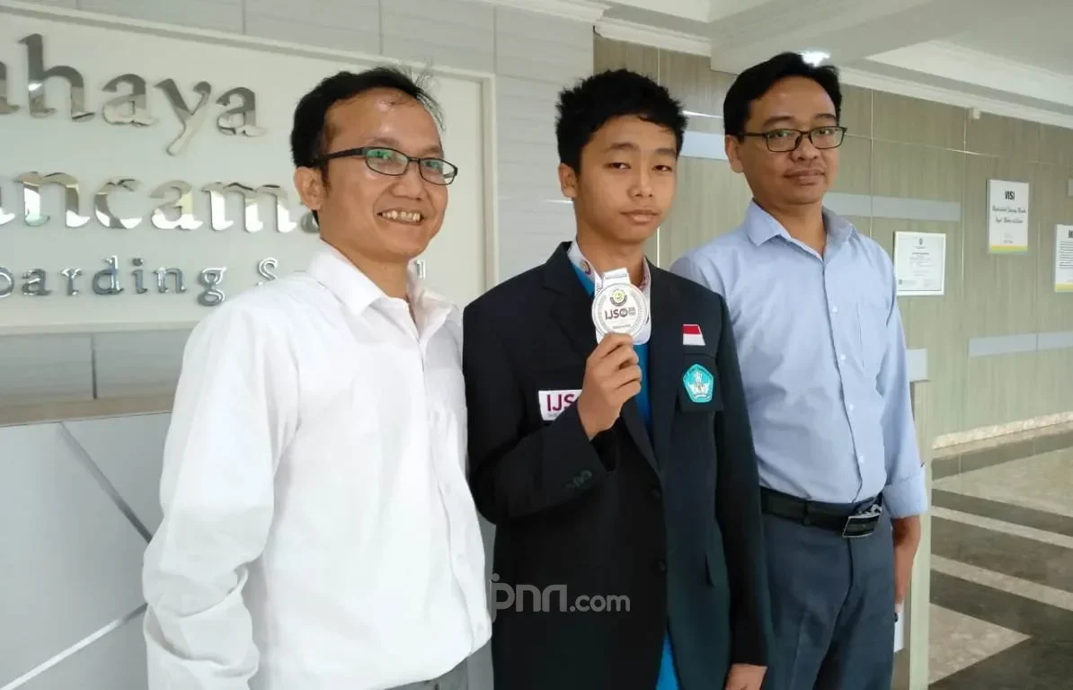 Faiq dan guru SMP Cahaya Rancamaya bangga dengan Medali Perunggu OSN Matematika.