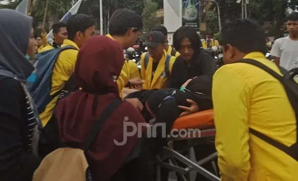Orang-orang menggotong seseorang di tandu di tengah kerumunan.