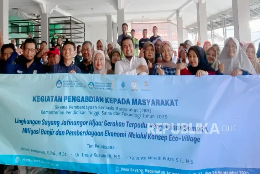 Tim UMB foto bersama di depan spanduk kegiatan pengabdian masyarakat di Desa Sayang.