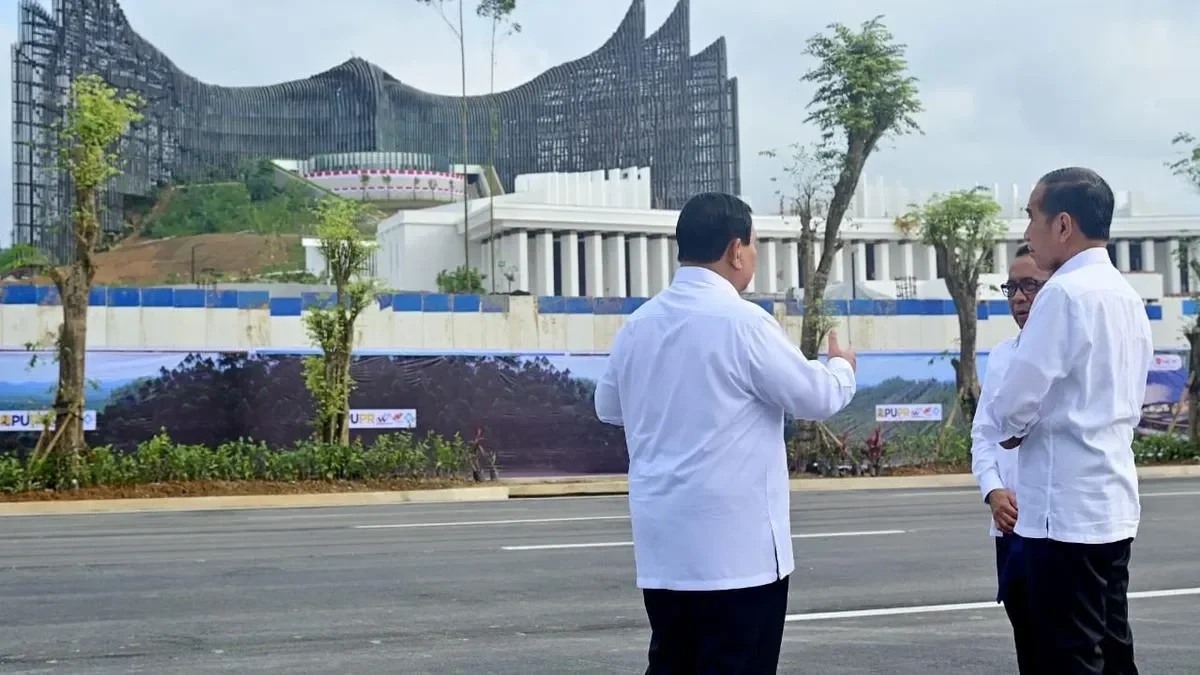 Prabowo dan Jokowi meninjau IKN dengan latar belakang pembangunan istana.