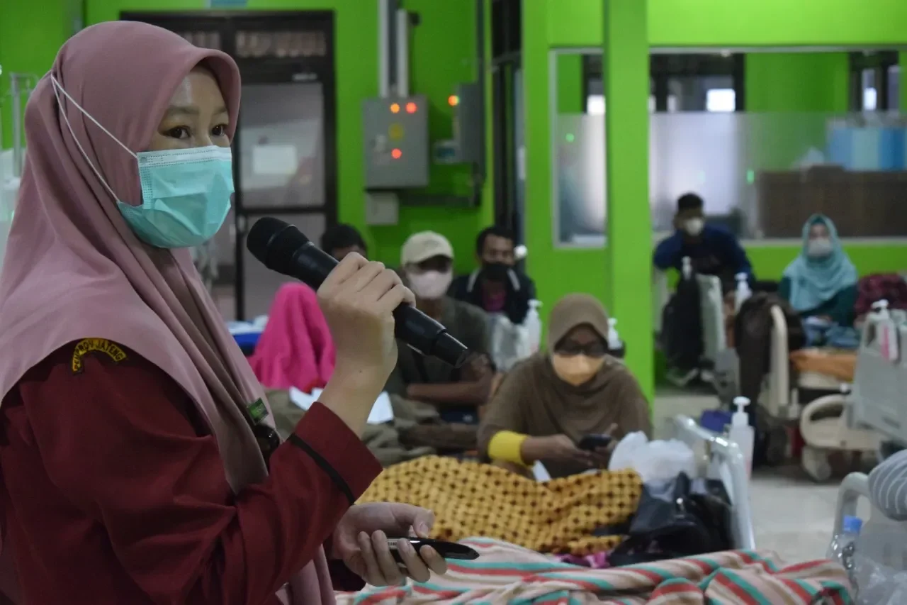 Presentasi tentang hemodialisis di fasilitas kesehatan, peserta memakai masker.