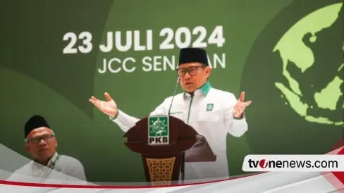 Muhaimin Iskandar tersenyum bahagia di podium dengan latar belakang logo PKB.