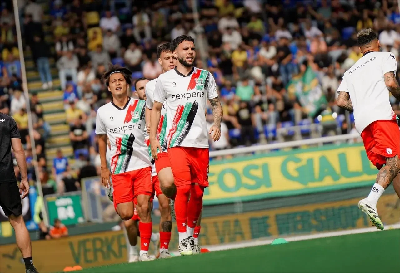 Calvin Verdonk, bek Timnas Indonesia, berjalan di lapangan hijau dengan seragam sepak bola.