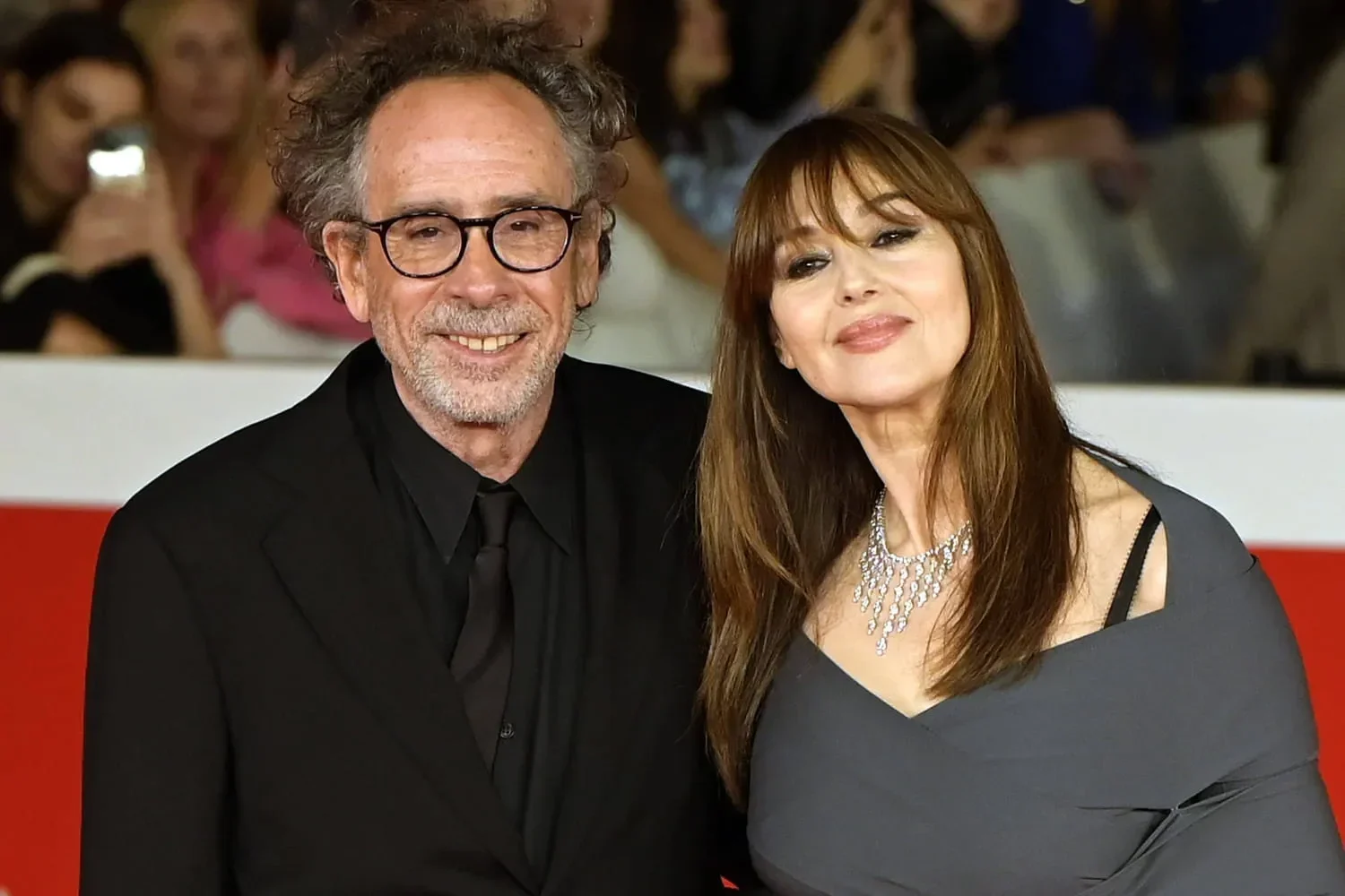 Tim Burton dan Monica Bellucci tersenyum di karpet merah.