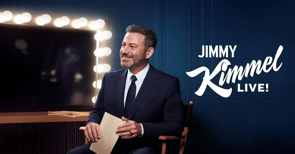 Komedian Jimmy Kimmel tersenyum mengenakan setelan jas, dengan logo "Jimmy Kimmel Live!" di latar belakang.