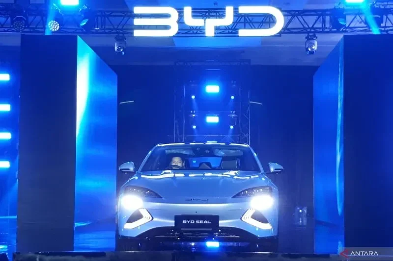 Mobil listrik BYD Seal ditampilkan dalam peluncuran yang disorot lampu biru.