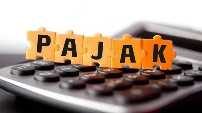Potongan puzzle bertuliskan "PAJAK" diletakkan di atas kalkulator, melambangkan kebijakan baru terkait pajak.