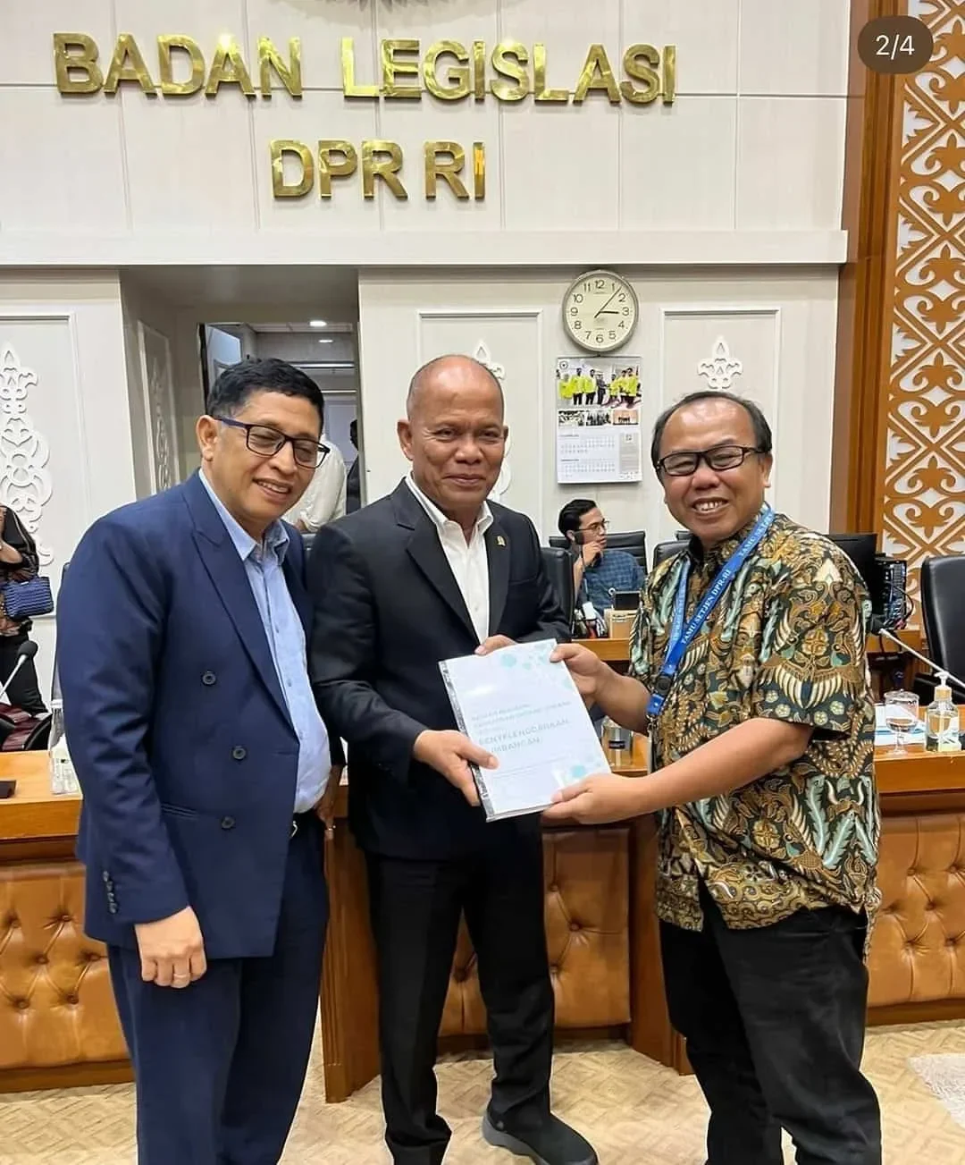 Tiga pejabat di Badan Legislasi DPR RI tersenyum saat serah terima dokumen RUU Prolegnas.