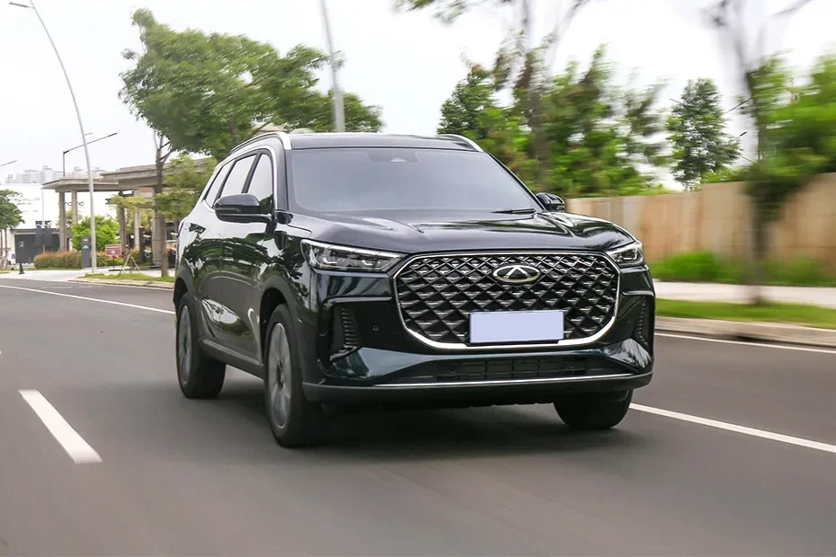 Chery Tiggo 8 Pro e+ berwarna hitam melaju di jalanan beraspal.