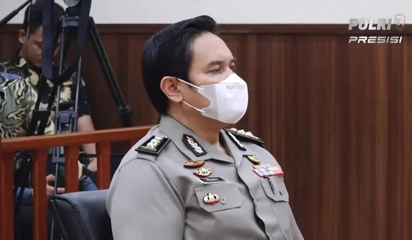 Pejabat Polda Metro Jaya berseragam lengkap, tertutup masker putih.