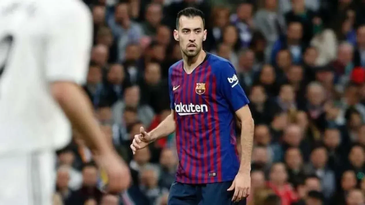 Sergio Busquets, gelandang legendaris, mengenakan jersey Barcelona biru-merah di lapangan sepak bola.