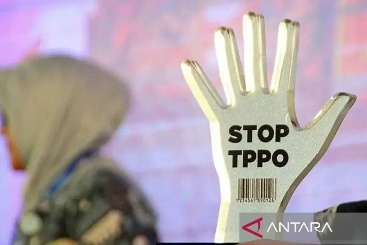 Tanda penghargaan berbentuk tangan bertuliskan "STOP TPPO" dengan latar belakang buram.