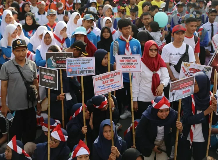 Demonstran membawa spanduk antikorupsi di tengah kerumunan warga Filipina.