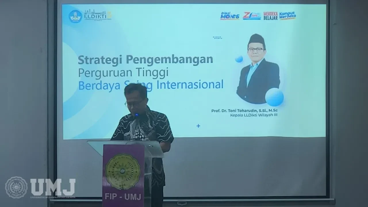 Pria berbatik di podium, depan slide presentasi Kepala LLDikti Wilayah III pada acara UMJ.