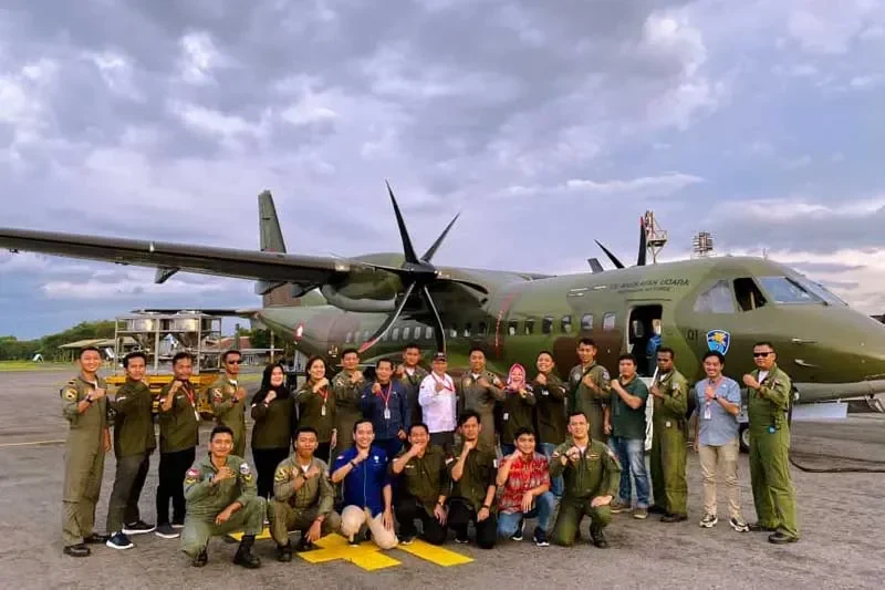 Kelompok gabungan BMKG dan BNPB berpose di depan pesawat militer untuk operasi modifikasi cuaca.