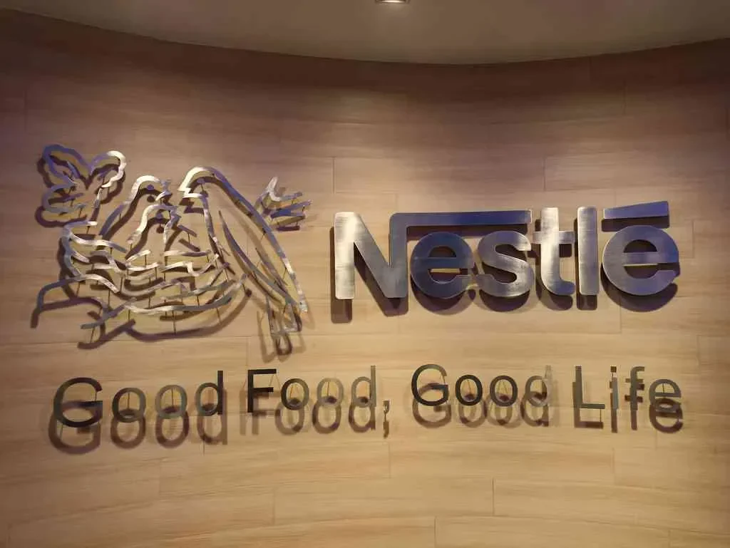 Logo Nestlé di dinding kayu, bertuliskan "Good Food, Good Life".
