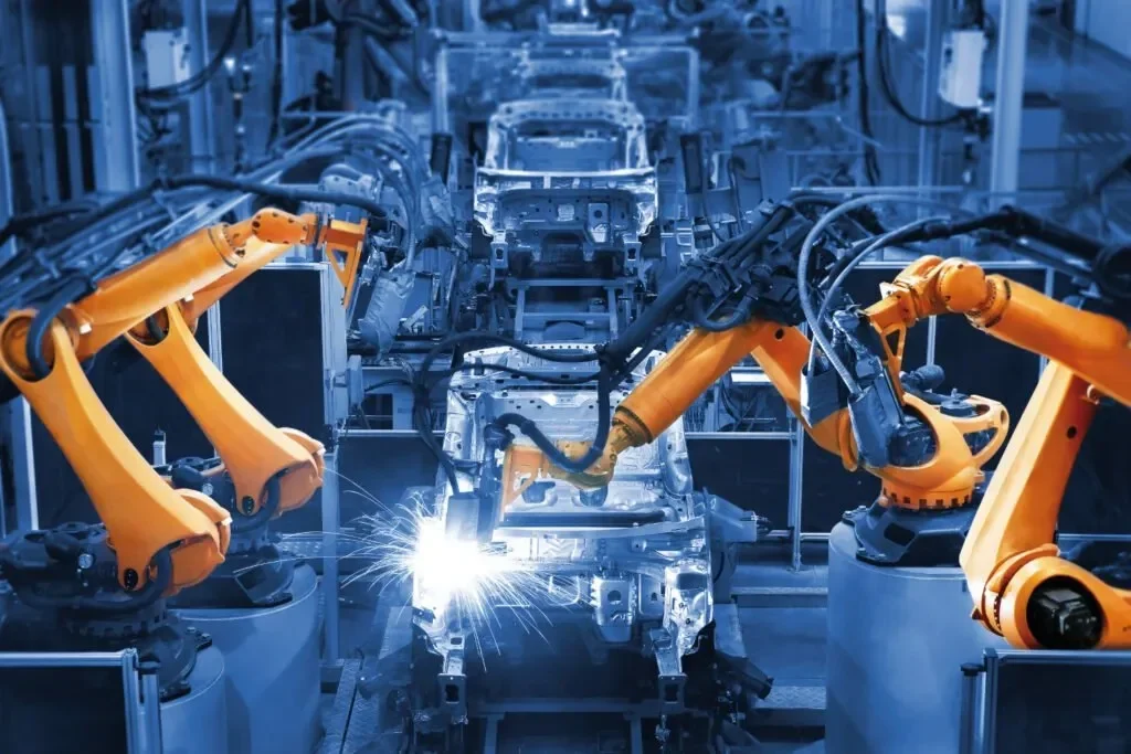 Lengan robot mengelas rangka mobil di fasilitas produksi industri otomotif.