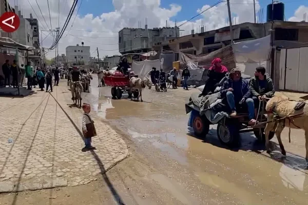 Warga Palestina menggunakan gerobak di jalanan Gaza yang rusak setelah konflik.