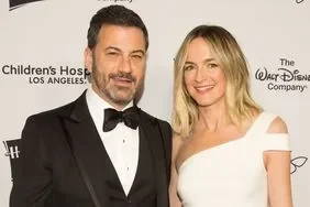 Jimmy Kimmel berpose dengan istrinya di acara amal, tersenyum ke kamera.