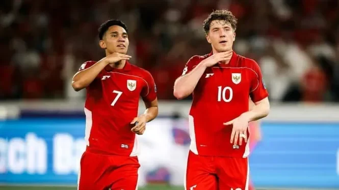 Dua pemain Timnas Indonesia merayakan gol dalam seragam merah.