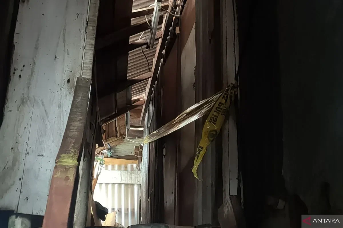 Garis polisi melintang di antara puing-puing bangunan tua yang rusak.