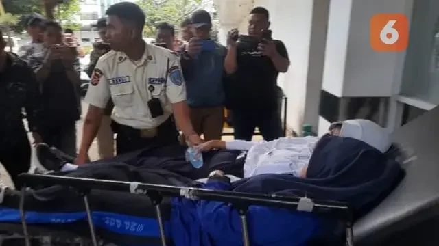 Petugas membawa pasien menggunakan tandu terkait kasus keracunan massal.
