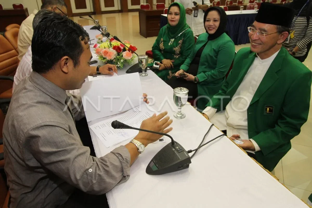 Tokoh PPP berbaju hijau dan peci tersenyum dalam pertemuan, di tengah konflik kepemimpinan partai.