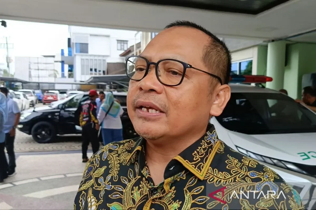 Pejabat BGN berbaju batik berekspresi saat ditemui di lokasi keracunan massal siswa.