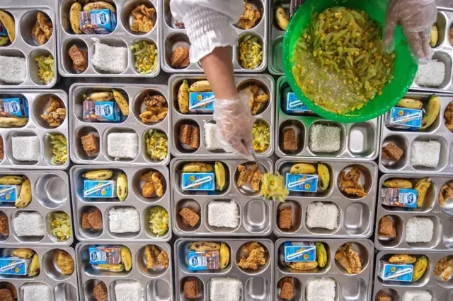 Penyiapan ribuan paket makanan dalam program Makanan Bergizi di wadah bento.
