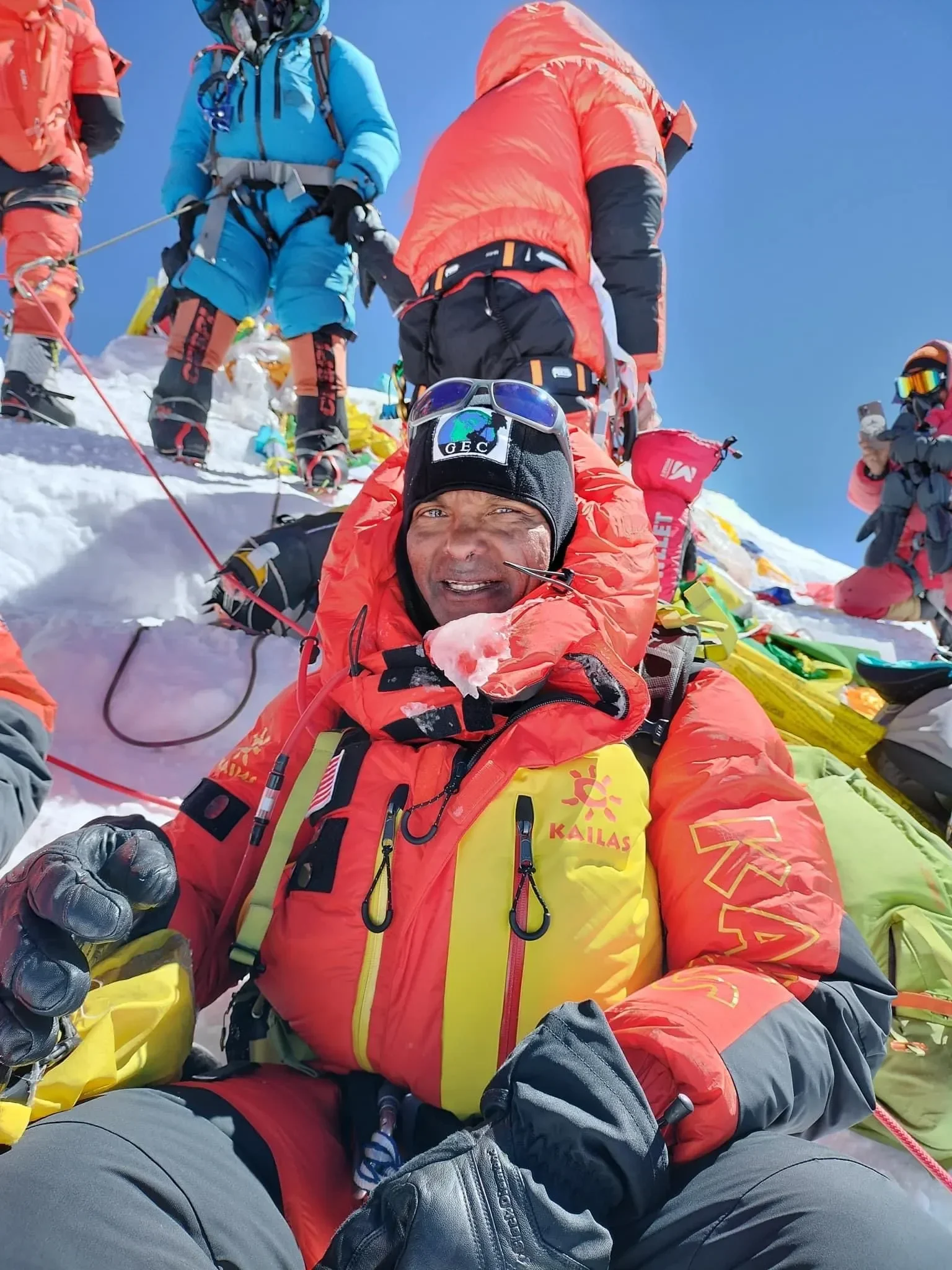 Andrzej Bargiel tersenyum dalam jaket gunung di puncak Everest bersalju bersama pendaki lain.