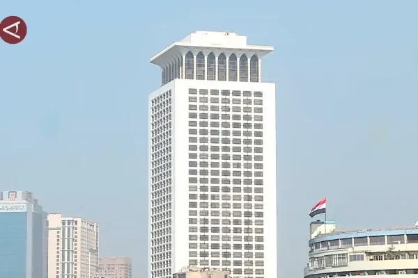 Gedung pencakar langit putih dengan bendera di tiang.