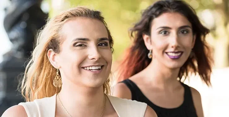 Dua wanita tersenyum, salah satunya kemungkinan Nguyen Huong Giang, outdoor dengan latar belakang blur.