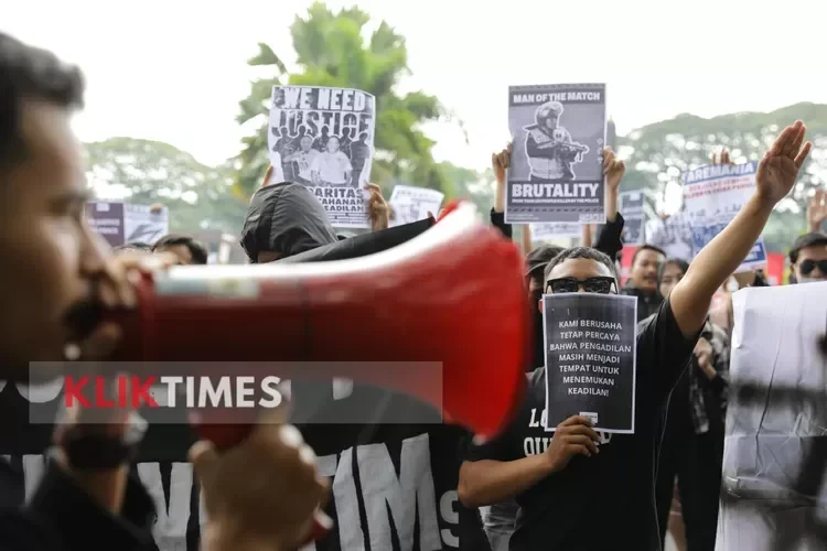 Aktivis hak asasi manusia berkumpul dan berdemonstrasi memegang poster menuntut keadilan.