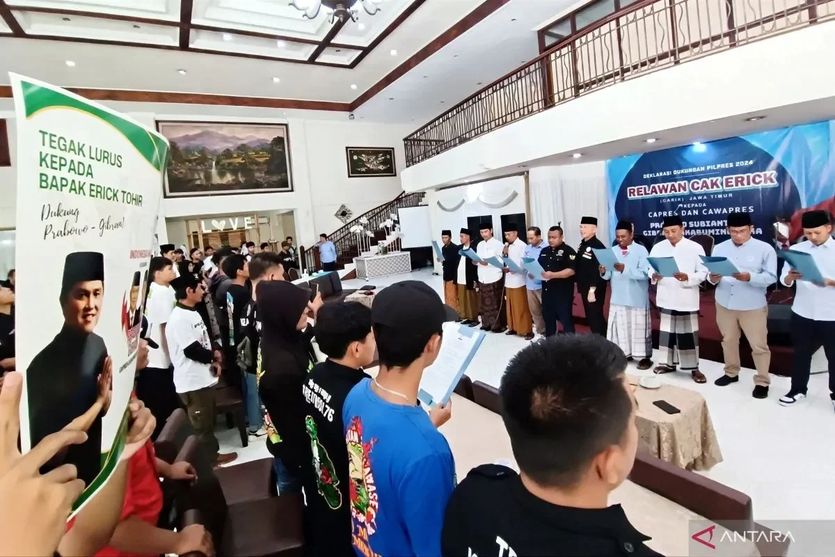Relawan mendukung Prabowo-Gibran, banner Erick Tohir terbentang di depan.