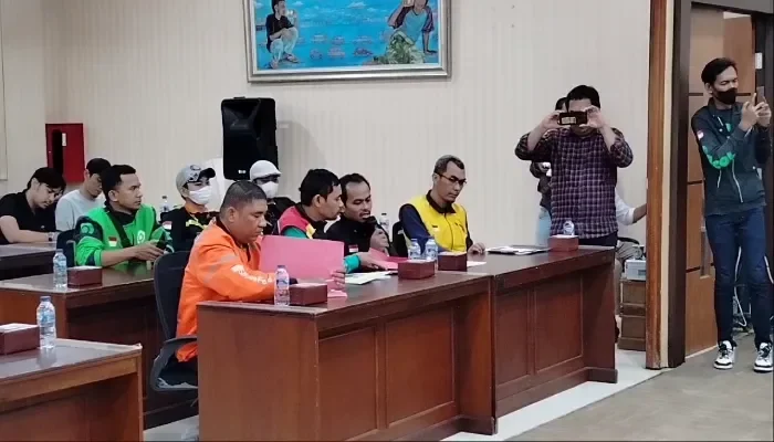 Pengemudi ojol dalam pertemuan, beberapa merekam, terkait inisiatif keamanan Kapolda Metro Jaya.