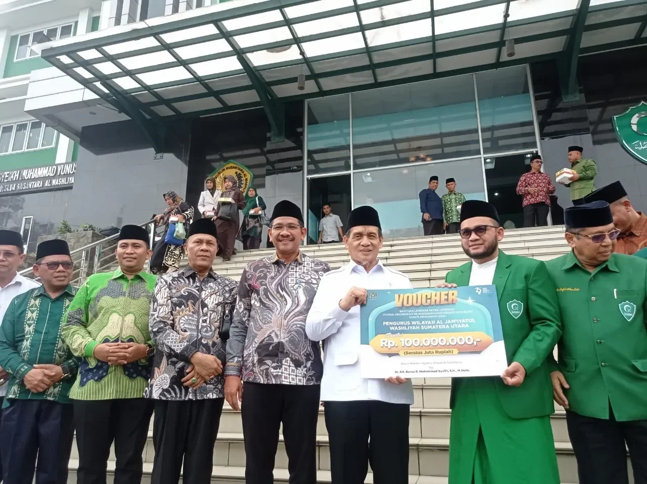 Wamenag Romo Muhammad Syafi'i menyerahkan voucher dana Rp 100 juta kepada pengurus Al Jam'iyatul Washliyah.