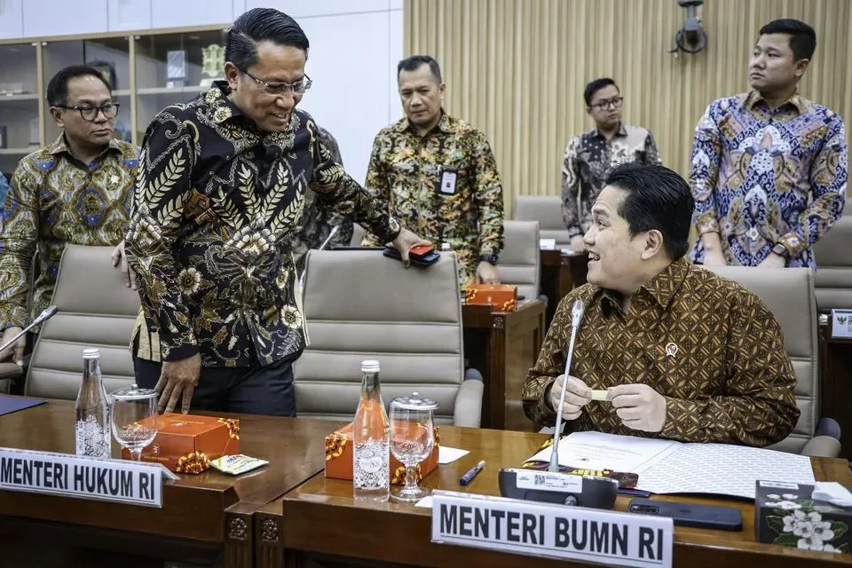 Menteri BUMN berdiskusi dengan pejabat lain di Gedung Parlemen.