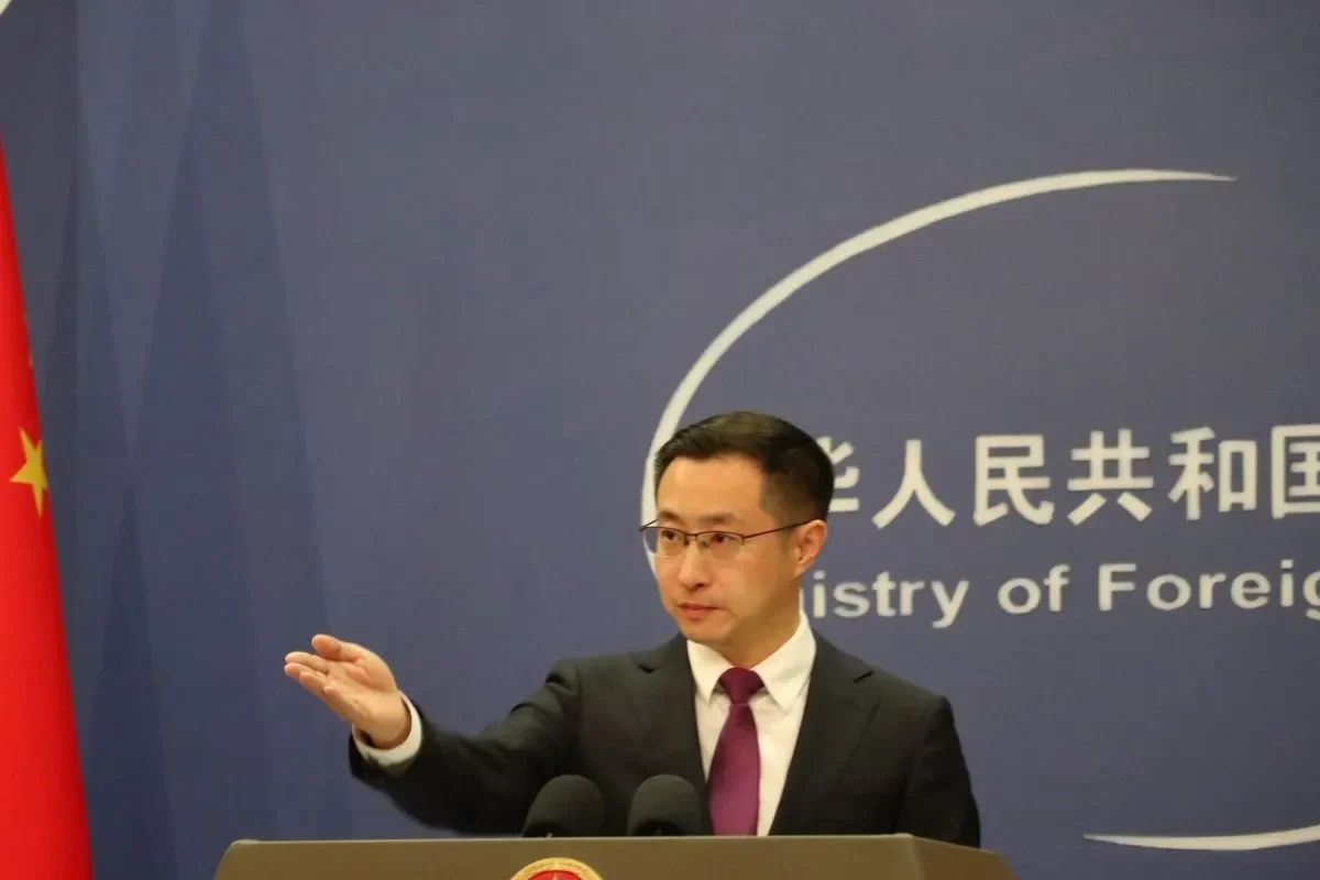 Juru bicara Kementerian Luar Negeri Tiongkok di podium dengan bendera nasional.