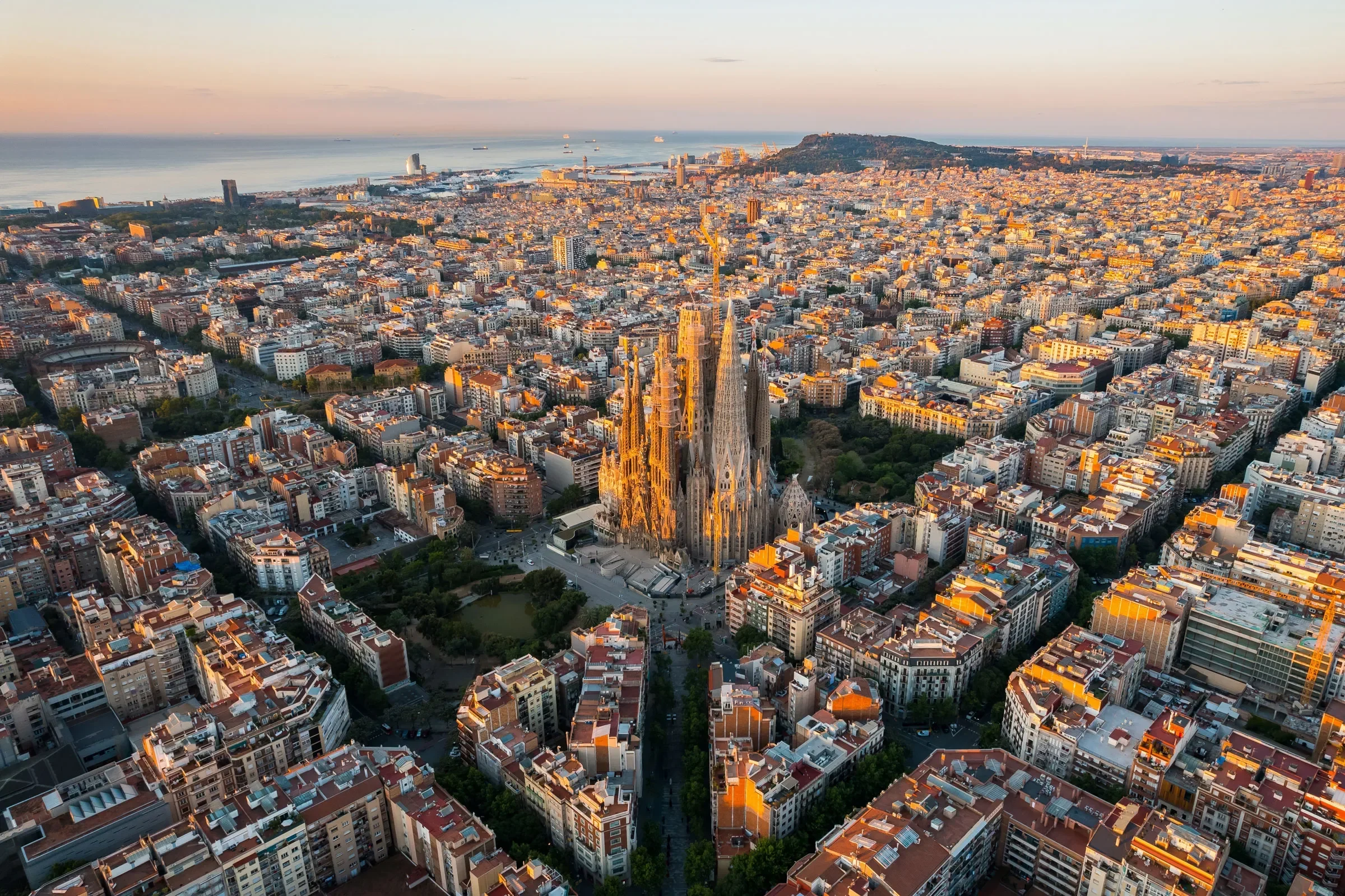 Pemandangan udara kota Barcelona saat matahari terbit dengan Sagrada Familia yang megah.