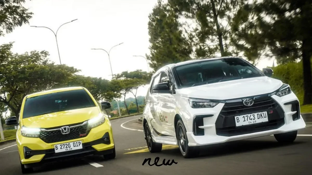 Dua mobil LCGC, Honda Brio kuning dan Toyota Agya putih, melaju di jalan.