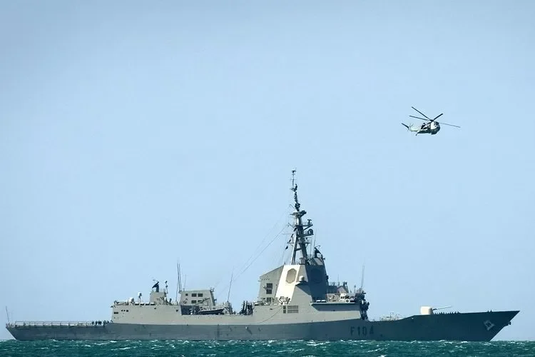Kapal fregat F104 berlayar di laut biru dengan helikopter di atasnya.