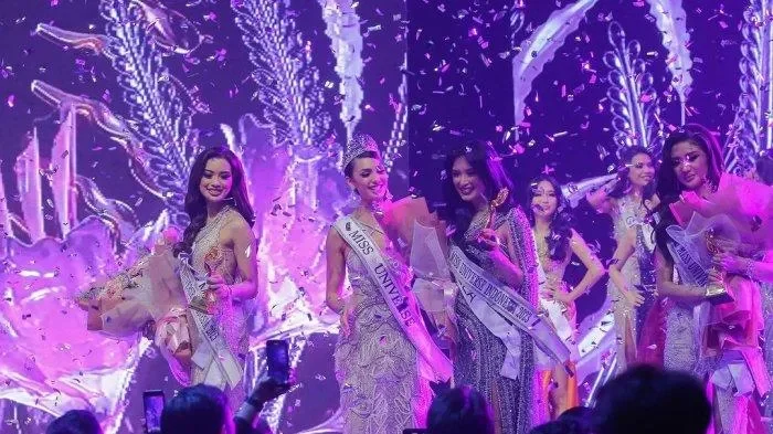 Pemenang Miss Universe Indonesia 2023 dirayakan dengan konfeti dan karangan bunga di atas panggung.