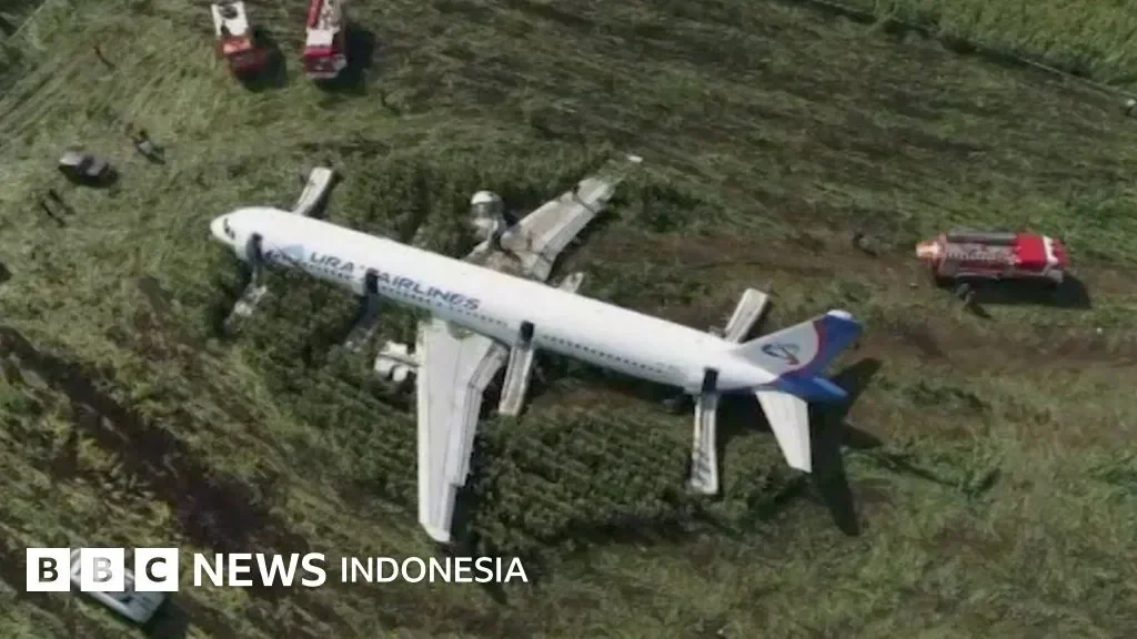 Pesawat Ural Airlines tergelincir di lapangan, dengan mobil pemadam kebakaran di dekatnya.