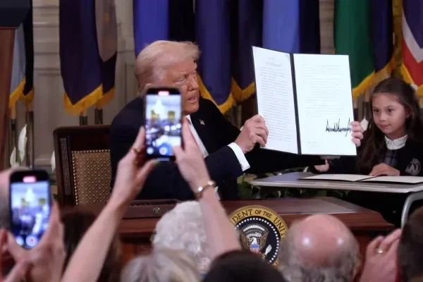 Presiden Donald Trump memamerkan perintah eksekutif setelah penandatanganan di Gedung Putih.