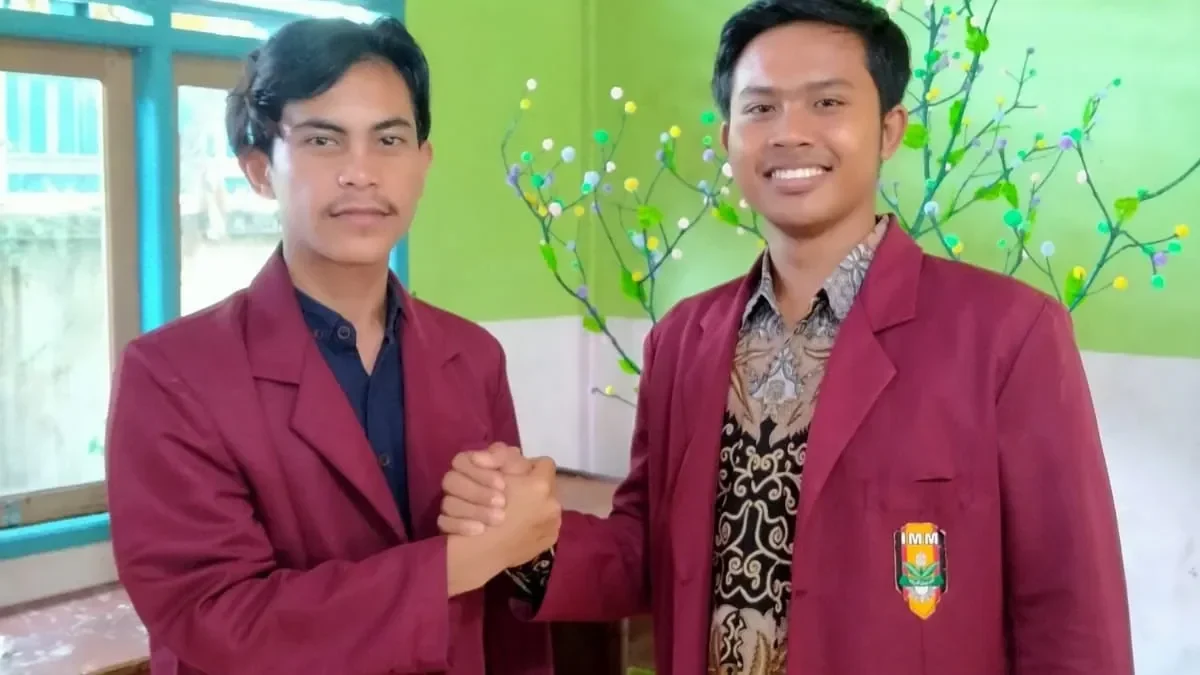 Dua pria muda berjas merah marun berjabat tangan, menandai dinamika internal partai.