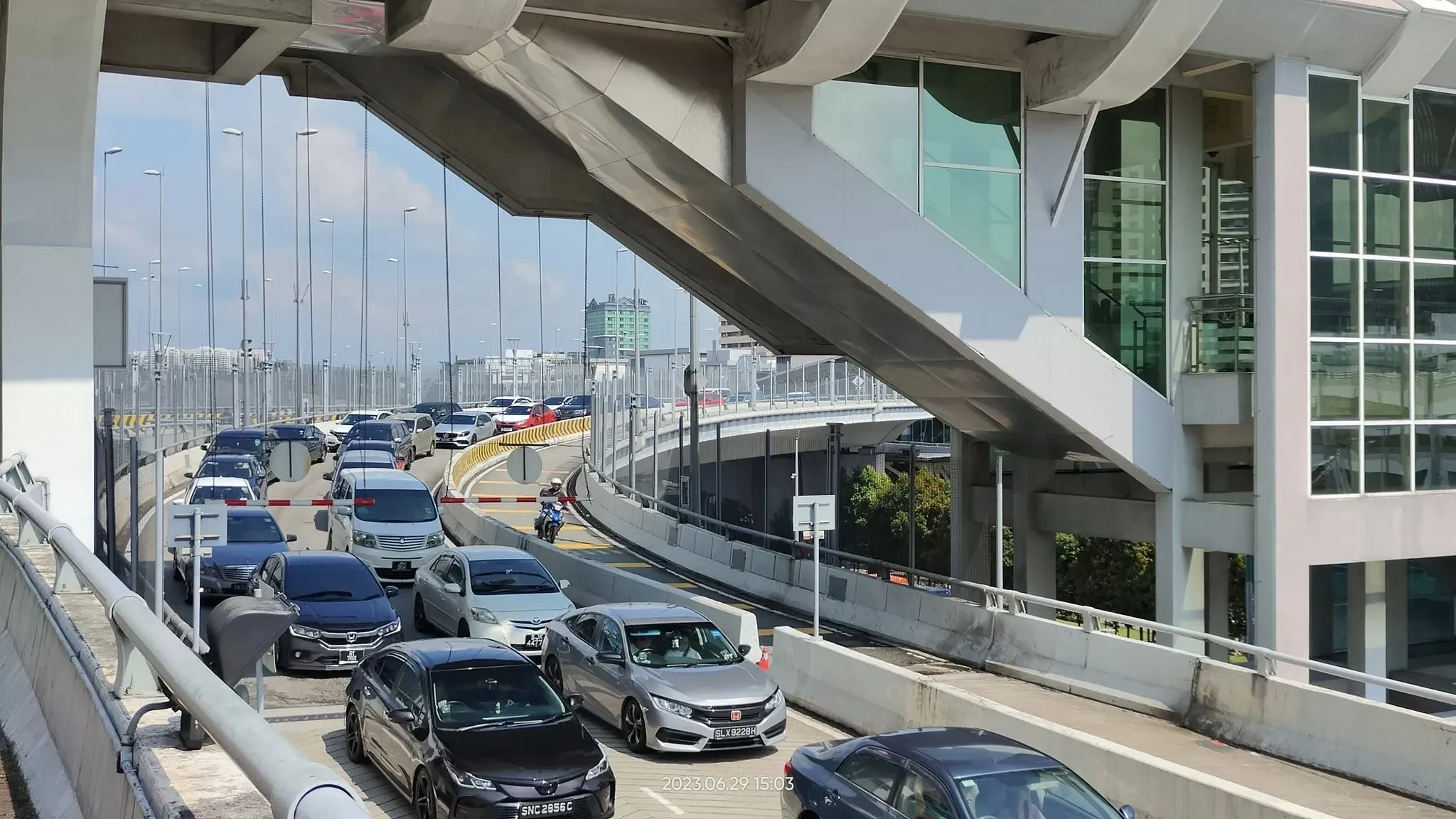 Kendaraan antre di pos pemeriksaan atau gerbang kedatangan internasional.