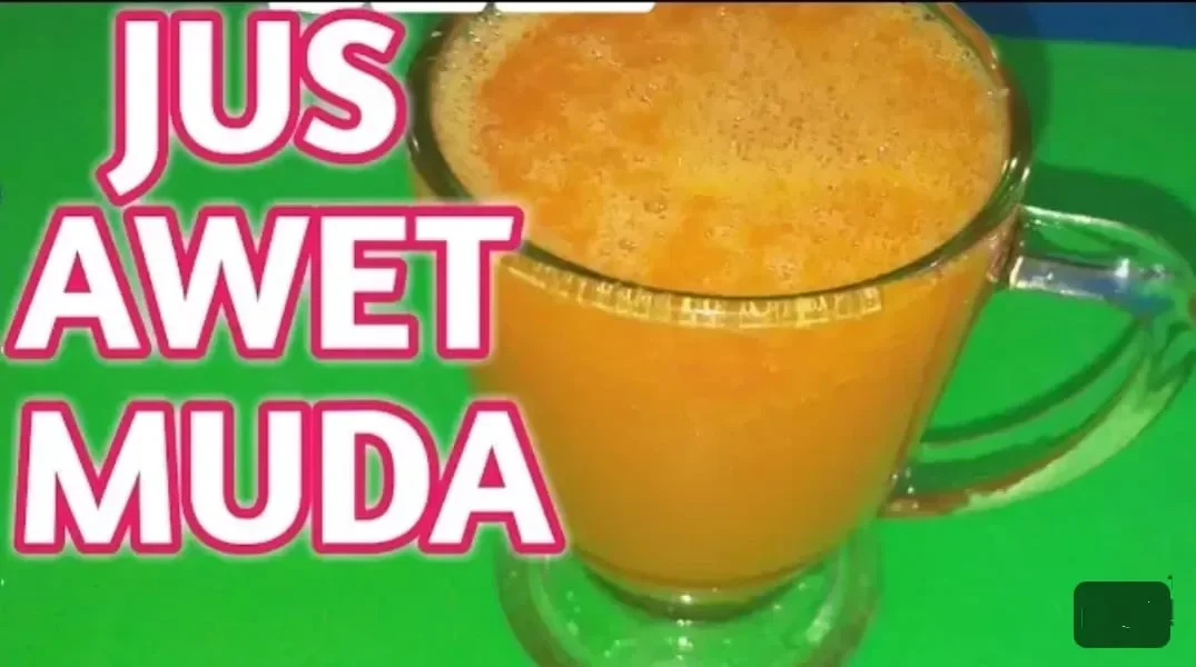 Segelas jus berwarna oranye cerah dengan teks "JUS AWET MUDA" di sebelahnya.