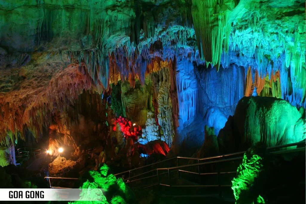 Keindahan stalaktit dan stalagmit Goa Gong Pacitan yang diterangi cahaya warna-warni.